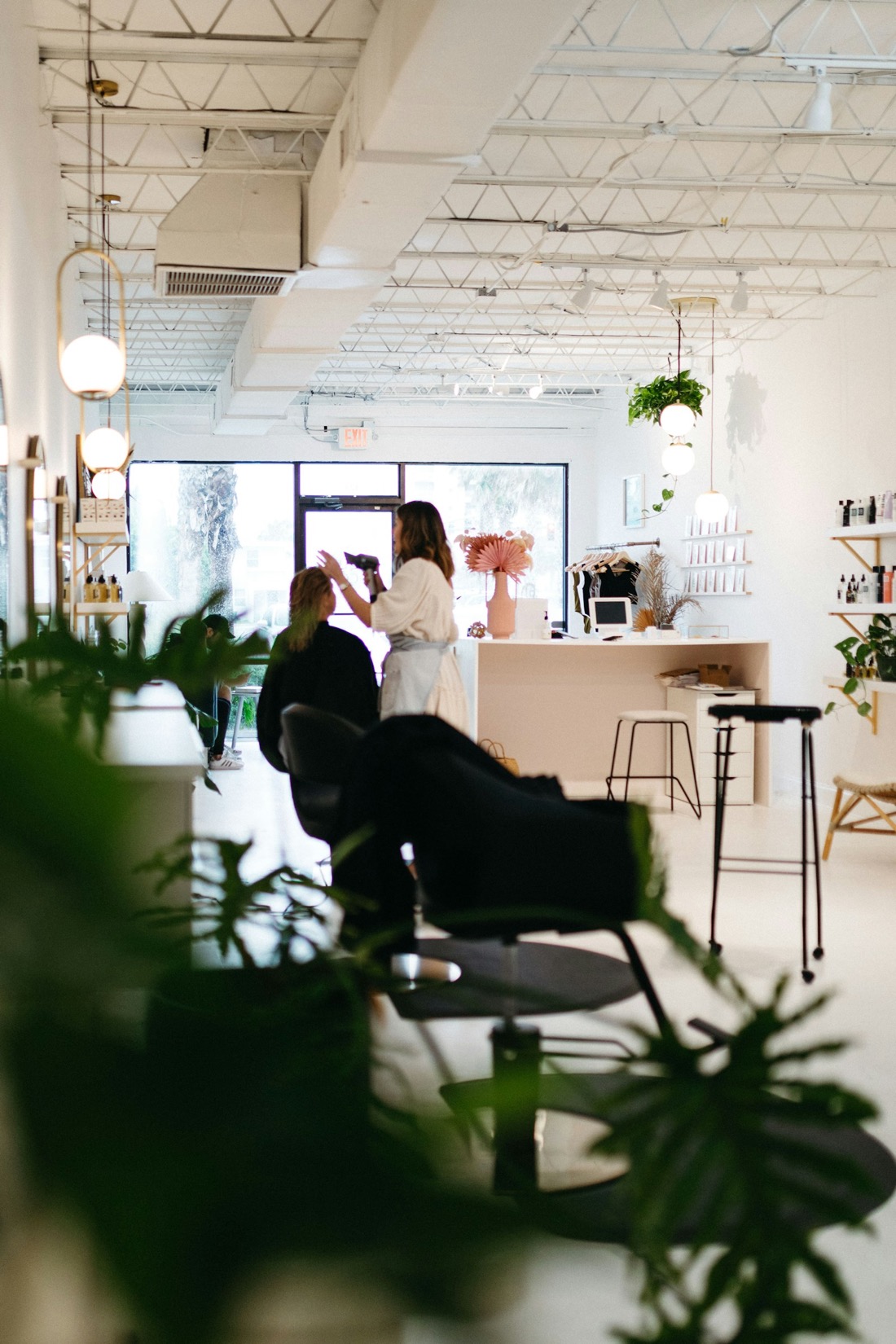 A bright salon studio with a styling chair and an arched mirror