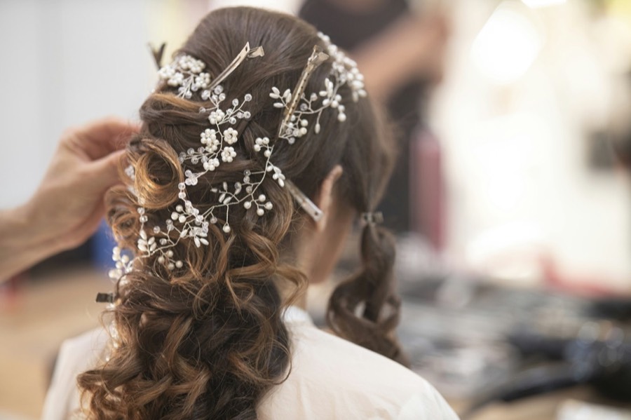 A loose bridal updo finished with small white flowers
